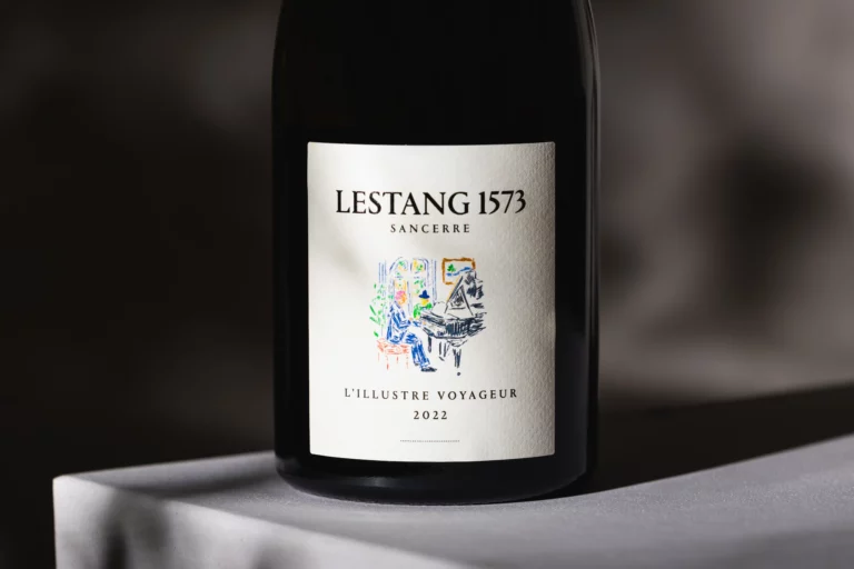 Détail en gros plan de l’étiquette “Lestang 1573 Sancerre – L’Illustre Voyageur 2022” sur une bouteille de vin, posée sur un socle blanc, avec une ombre diffuse en arrière-plan.